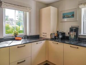 a kitchen with white cabinets and a window at Torrance At Abbey Park Avenue in St. Andrews +9 photos