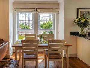 a dining room with a table and chairs and a window at Torrance At Abbey Park Avenue in St. Andrews