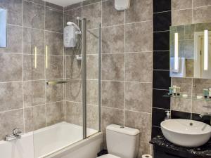 a bathroom with a shower and a toilet and a sink at Roxy's Cottage - Uk44687 in Burnopfield