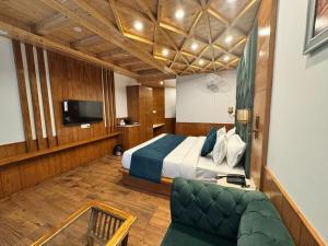 una camera da letto con un letto, un divano e una TV di White Season Resort - Mountain View With Premium Rooms # Luxury Stay in Manali a Manāli