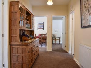 a hallway with a large wooden cabinet and a dining room at 8 Lowther Gardens in Grange Over Sands +8 photos