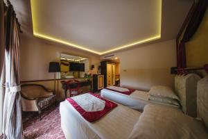 een hotelkamer met twee bedden en een stoel bij Domeniile Martinutzi - Hotel Cardinal in Alba Iulia