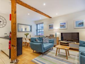 sala de estar con sillas azules y TV en The Pottery, en Dartmouth