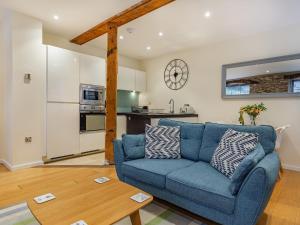 Una sala de estar con un sofá azul y una mesa. en The Pottery, en Dartmouth