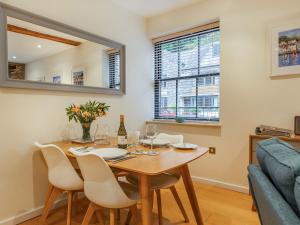 Un comedor con una mesa y sillas y un sofá. en The Pottery, en Dartmouth