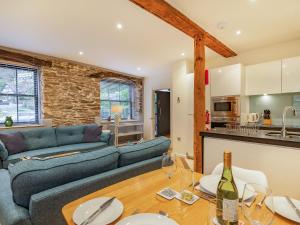 Una sala de estar con un sofá y una mesa con copas de vino. en The Pottery, en Dartmouth