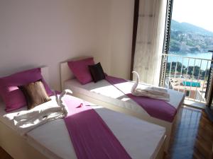 two beds in a room with a large window at Apartment Anet with free parking in Dubrovnik