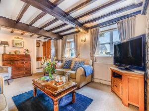 a living room with a couch and a tv at Perkins Cottage in Ashover
