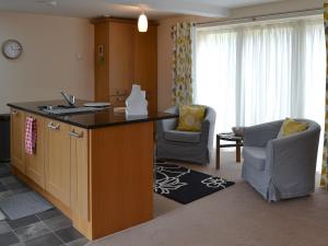 a kitchen with a sink and a living room at Stable Cottage in Chatton
