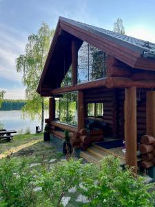 a log cabin with a view of a lake at River's Whisper Cottage in Rovaniemi