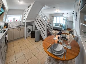 a kitchen and dining room with a table and stairs at Apple Blossom Cottage - Uk46648 in Cheddar
