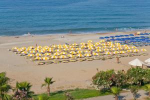 een groep parasols en stoelen op een strand bij Monte Carlo Hotel in Alanya