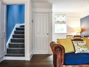 a living room with a blue couch and stairs at Chapel Cottage in Robin Hood's Bay