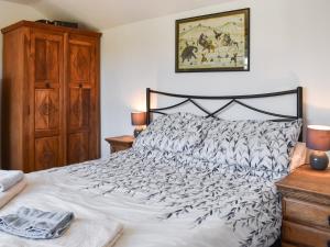 a bedroom with a bed with a black and white comforter at Bray View Cottage in Davidstow