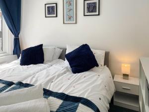 a white bed with blue pillows in a bedroom at Rutland Retreat in Filey