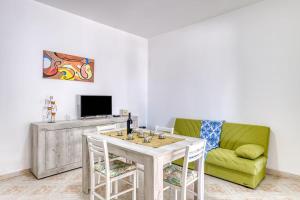 a living room with a table and a green couch at Salentoandmore - Smeralda Onda Blu in Marina di Pescoluse