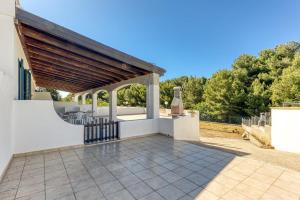 an outdoor patio with awning and a grill at Salentoandmore - Smeralda Onda Blu in Marina di Pescoluse