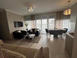 a living room with a couch and a table at Paris Yard Apartman with free parking in Debrecen