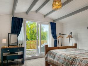 a bedroom with a bed and a sliding glass door at Lake View Cottage in Belper +5 photos