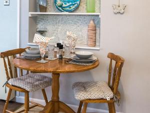 a dining room table with two chairs and a wooden table at Apple Blossom Cottage - Uk46648 in Cheddar