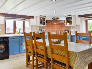 a kitchen with blue cabinets and a table and chairs at The Imaginary Barn in Hartland +22 photos