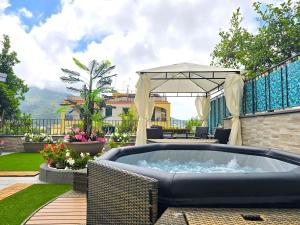 a patio with a hot tub and a gazebo at Grazy Home - Bright new Apt with Terrace and Jacuzzi in Vico Equense