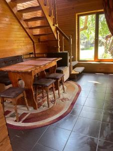 a dining room with a wooden table and chairs at Mandrivnyk in Mykulychyn