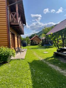 una casa con un patio de césped al lado de un edificio en Mandrivnyk, en Mykulychyn