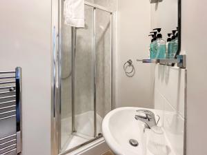 a white bathroom with a shower and a sink at Pier View Apartment 2 - Uk48502 in Skegness
