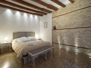 1 dormitorio con cama y banco. en Casa Margherita, en Venecia