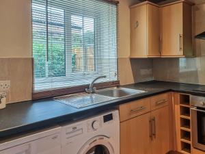 eine Küche mit Spüle und Waschmaschine in der Unterkunft Half Moon Cottage in Brafferton + 6 Fotos