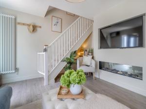 a living room with a staircase with a large tv at Ty Mor in Abersoch