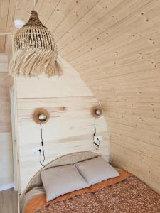 una cama en una habitación con una pared de madera en Tiny House De Bosksjonger, en Westergeest