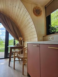 cocina con techo abovedado y mesa en Tiny House De Bosksjonger, en Westergeest