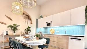 a kitchen with a table and chairs in a room at EcoCasa 12PAX perfecta grupos, reforma lujo, junto parada Burjassot metrovalencia, cerca centro Valencia y playa, lavadora, secadora equipamiento total in Burjasot +10 photos