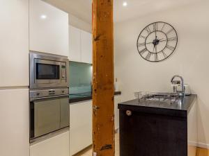 Una cocina con un fregadero y un reloj en la pared. en The Pottery, en Dartmouth 8 fotos más