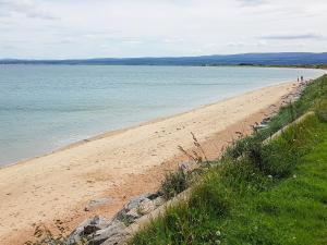 a sandy beach with the ocean in the background at The Dolphin - Uk31004 in Avoch