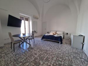 a bedroom with a bed and a table and a desk at Templari Suite in Mesagne