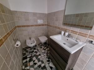 a bathroom with a sink and a toilet at Templari Suite in Mesagne +3 photos