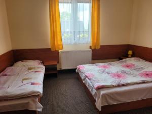 a bedroom with two beds and a window with yellow curtains at Willa Republika  +7 photos