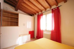 a bedroom with red curtains and a window at Nisportino Domus in Rio nellʼElba