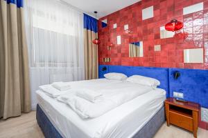 a bedroom with a bed with a blue and red wall at Art Box - Gdańska Brzeźno in Gdańsk