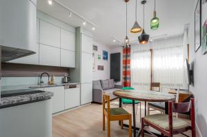a kitchen and dining room with a table and chairs at Art Box - Gdańska Brzeźno in Gdańsk +4 photos