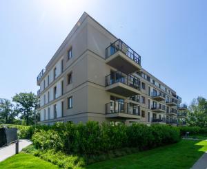 an apartment building with balconies and a lawn at Art Box - Gdańska Brzeźno in Gdańsk
