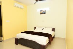 a bedroom with a bed in a room at Hotel Amar in Belagula