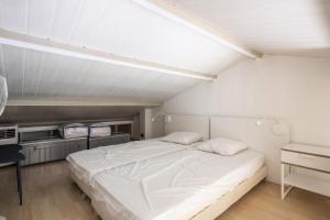 - duże białe łóżko w pokoju z biurkiem w obiekcie Les Appartements aux Restanques du Golfe de St Tropez - maeva Home - Appartement avec mezzanine 2 Pièces 4 Personnes - Confort MAE-3700 w mieście Grimaud +20 zdjęć