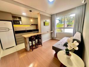 a small living room with a couch and a kitchen at Urban Apt 601 Comfortable and Complete in Caxias do Sul