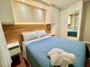 a bedroom with a blue bed and a mirror at Urban Apt 601 Comfortable and Complete in Caxias do Sul