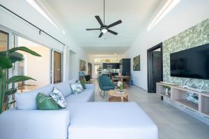 a living room with a white couch and a flat screen tv at Ocean View, Style, Freedom in Sosúa