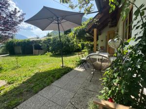 a patio with a table and an umbrella at Carinthian Freedom Lodge Goritschach in Größing